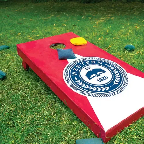 A branded cornhole board, painted red and white with a blue university logo