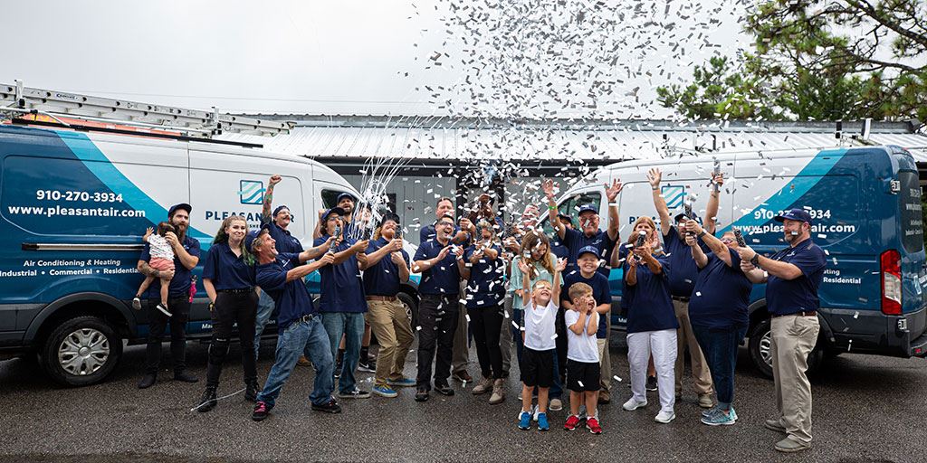 Pleasant Air's team shooting off confetti cannons in front of their vans
